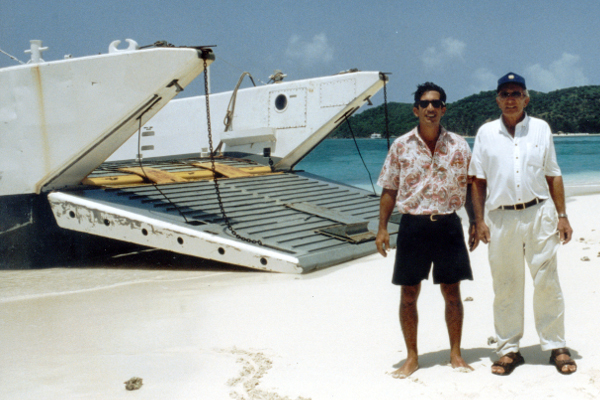 Two Men on a Beach In Front of a Boat