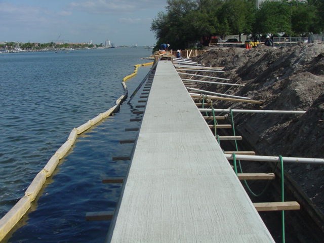 Sea wall with floating barrier